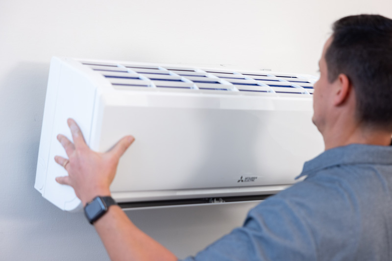 Technician Installing Mitsubishi Electric Mini-split Wall Mounted Unit.